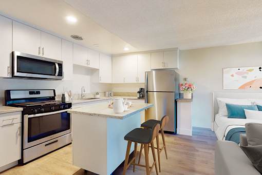 A kitchen with white cabinets and a blue island.
