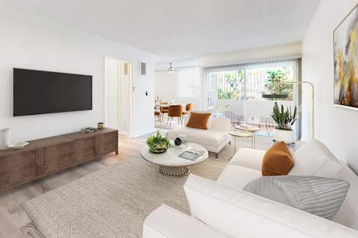A living room with a white couch, a coffee table, and a flat screen TV.