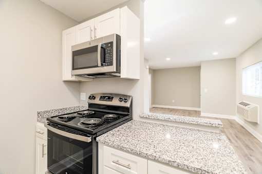 A kitchen with a stove and microwave.