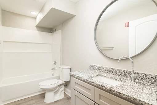 A white bathroom with a toilet, sink, and bathtub.