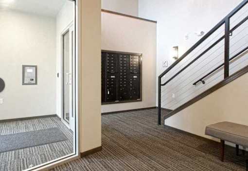 A staircase with a black railing and a bench on the landing.