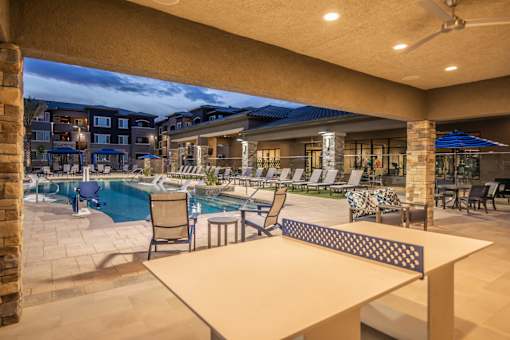 a patio with tables and chairs and a swimming pool at Level 25 at The Curve by Picerne, Las Vegas, NV 89148