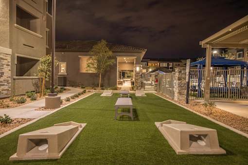 a courtyard with benches and tables at night at Level 25 at The Curve by Picerne, Las Vegas, 89148