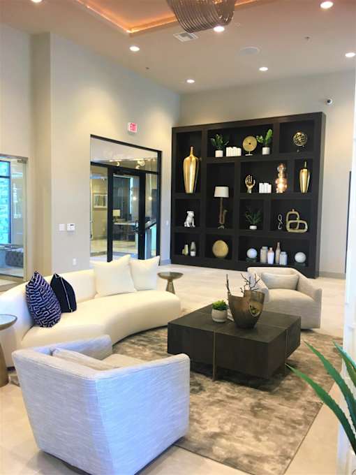 a living room with white furniture and a black display case at Level 25 at The Curve by Picerne, Nevada 89148
