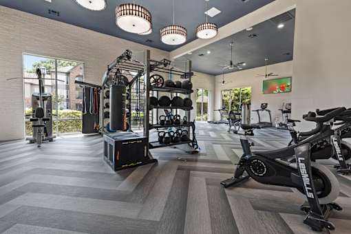 State-of-the-art gym with a variety of equipment including treadmills, weights, and exercise bikes at Asheville at Spring Branch apartments in Houston, TX