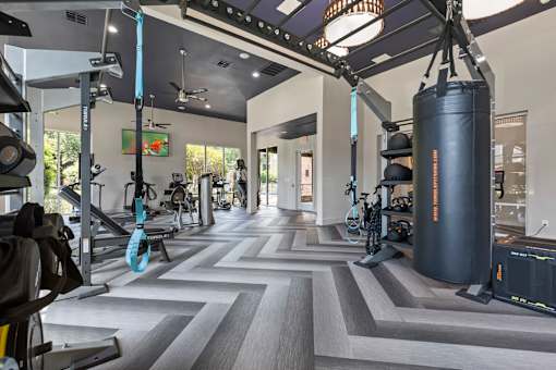 Large gym with a variety of equipment including a punching bag at Asheville at Spring Branch apartments in Houston, TX