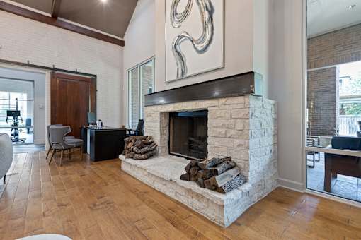 leasing office interior lounge area with a fireplace at Asheville at Spring Branch apartments in Houston, TX