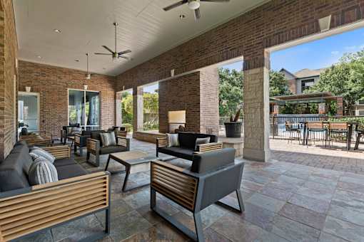Shaded outdoor patio area with a table and chairs at Asheville at Spring Branch apartments in Houston, TX