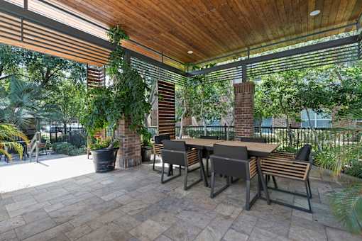 Pavilion by the pool with a table and chairs perfect for outdoor relaxation at Asheville at Spring Branch apartments in Houston, TX