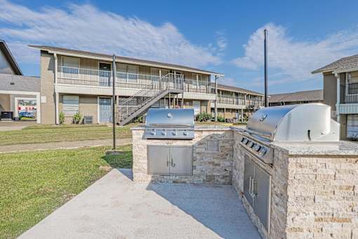 A paved barbeque area with apartment buildings in the background at The Creole Apartments in Shreveport, LA