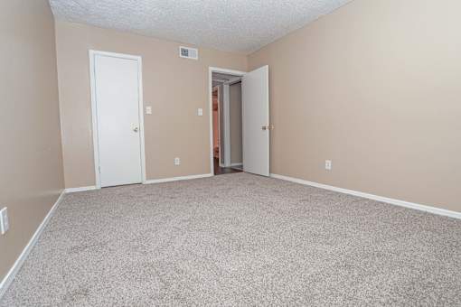 A bedroom room with a carpeted floor and closet  at The Creole Apartments in Shreveport, LA