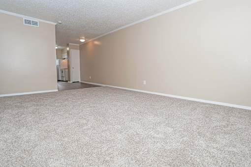 A spacious living room with beige walls and carpeted floor  at The Creole Apartments in Shreveport, LA