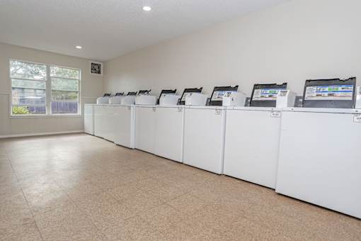 A row of washing machines inside an onsite laundry facility at The Creole Apartments in Shreveport, LA