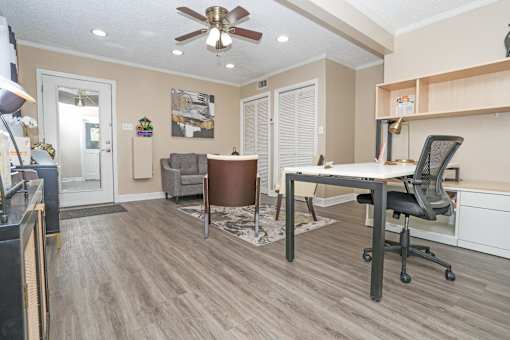 A leasing office with a ceiling fan and a desk with a computer  at The Creole Apartments in Shreveport, LA