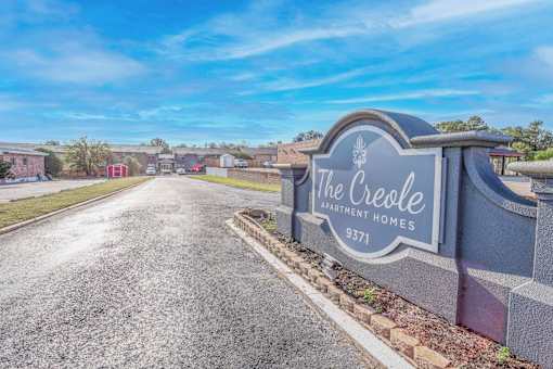 A stone sign for "The Creole Apartment Homes" is at the entrance to The Creole Apartments in Shreveport, LA