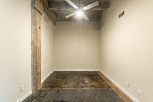 a room with a concrete floor and a ceiling fan