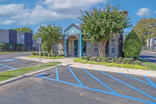 A blue and white leasing office with disabled parking spots at The Drake in Bossier City, LA