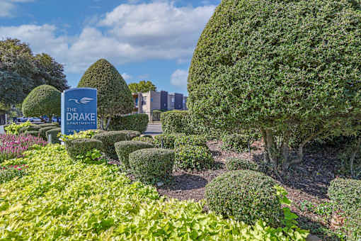 Green bushes surround a "The Drakes Apartments" sign at The Drake in Bossier City, LA