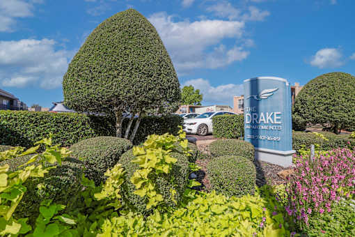 "The Drake Apartments" sign in front of a well-manicured garden at The Drake in Bossier City, LA