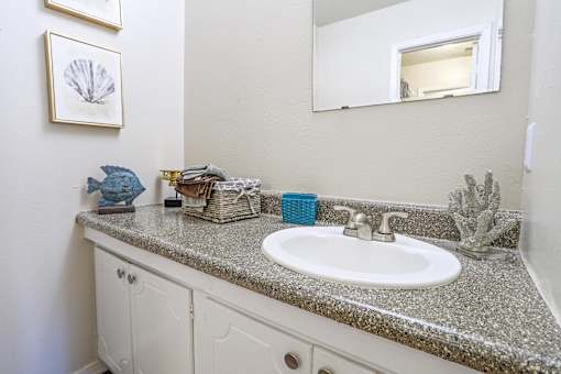 A bathroom with a white sink and a mirror above it at The Drake in Bossier City, LA
