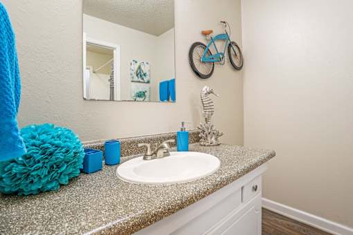 A bathroom with a blue towel and a mirror on the wall at The Drake in Bossier City, LA