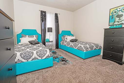 A room with two beds and a dresser at The Drake in Bossier City, LA