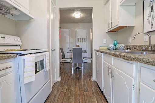 A kitchen with a white stovetop oven and cabinets at The Drake in Bossier City, LA