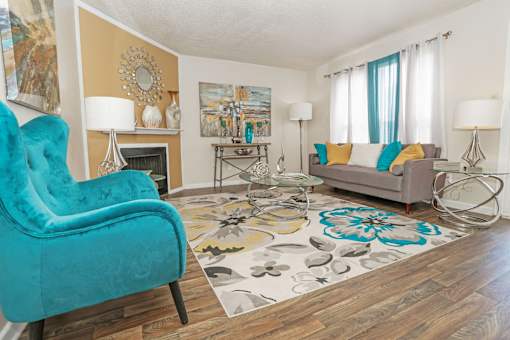 A living room with a blue chair and a grey couch at The Drake in Bossier City, LA