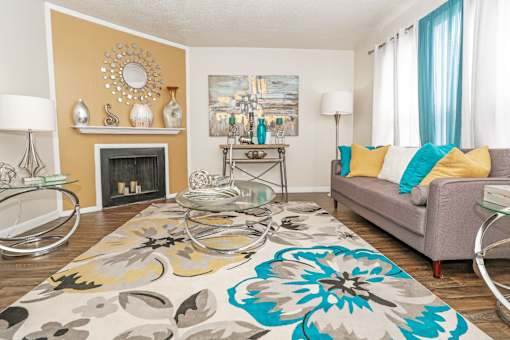 A living room with a grey couch and a fireplace at The Drake in Bossier City, LA