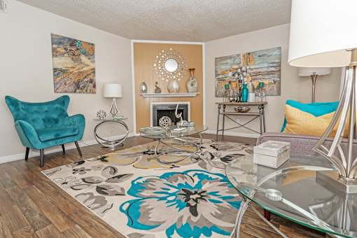 A living room with a fireplace and an area rug at The Drake in Bossier City, LA