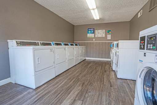 An onsite laundry facility with rows of washers and dryers at Magnolia Apartments in Shreveport, LA