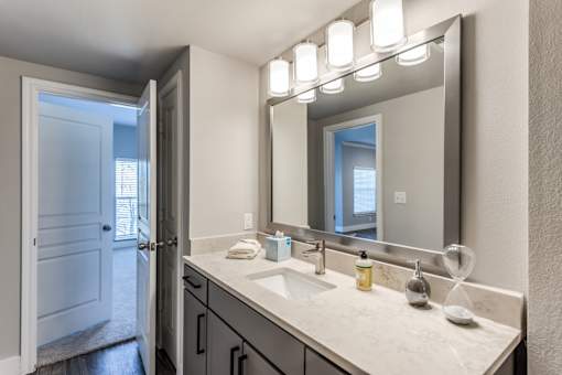 A2 model bathroom large vanity with quartz countertop at Asheville at Spring Branch apartments in Houston, TX
