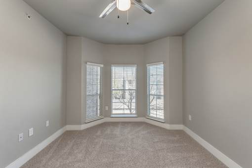 A2 model bedroom bay window and ceiling fan at Asheville at Spring Branch apartments in Houston, TX