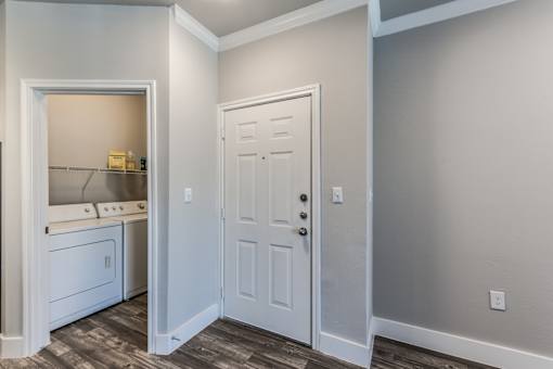 A2 model apartment entrance next to laundry closet at Asheville at Spring Branch apartments in Houston, TX
