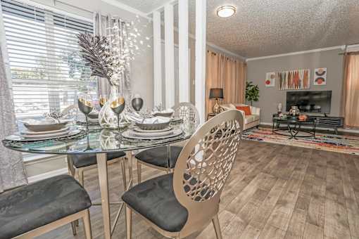 A dining room in our model apartment with a glass table and chairs at Maplewood apartments in Shreveport, LA.