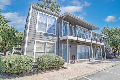 A grey two-story apartment building with the entrance to 4 units at Maplewood apartments in Shreveport, LA.