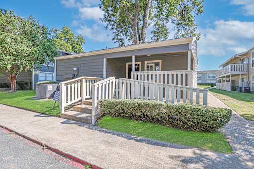 Exterior of our onsite laundry facility with a porch with a railing at Maplewood apartments in Shreveport, LA.