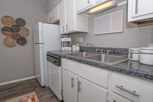 Model kitchen with white cabinets and a white fridge at Maplewood apartments in Shreveport, LA.