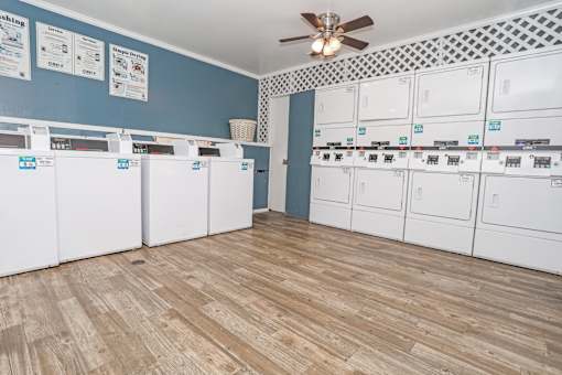 Onsite laundry room with blue walls washer and dryers at Maplewood apartments in Shreveport, LA.