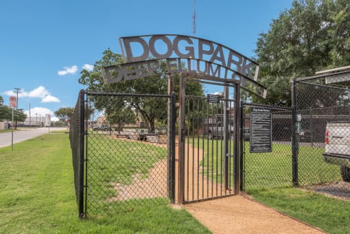 a dog park with a gate and a sign that says dog park