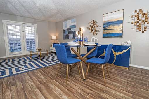 Dining area in the model unit with table and chairs next to living room at The Oasis apartments in Bossier City, LA