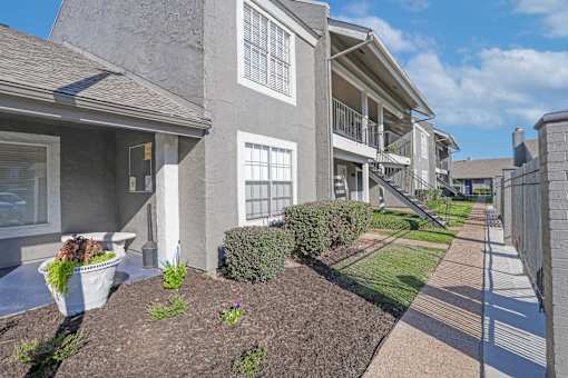 A grey building with a white door and windows at The Oasis apartments in Bossier City, LA