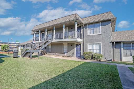 A two-story building with stairway up to units at The Oasis apartments in Bossier City, LA
