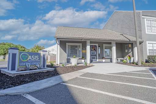 Leasing office entrance with property signage that says Oasis Leasing Office at The Oasis apartments in Bossier City, LA