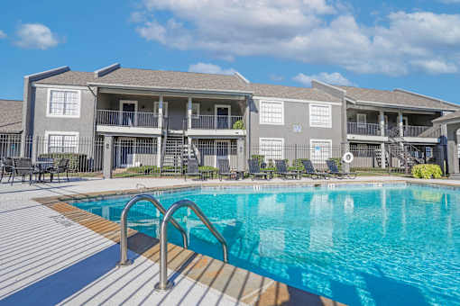A swimming pool in front of apartment buildings at The Oasis apartments in Bossier City, LA