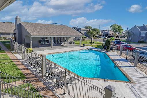Large swimming pool surrounded by a fence behind the leasing office at The Oasis apartments in Bossier City, LA.