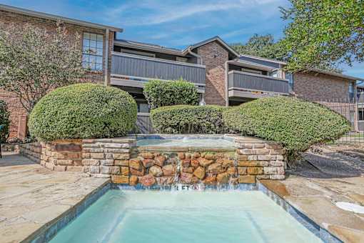 Fountain feature of the pool with apartments in the background at The Pearl apartments in Shreveport, LA