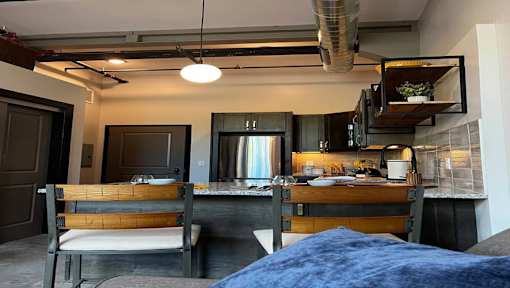 A bedroom with a bed, a table, and a chair.