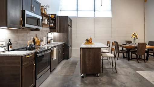 A modern kitchen with dark wood cabinets and stainless steel appliances.