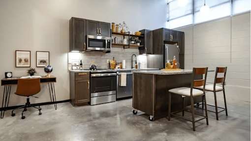 A modern kitchen with a large island and stainless steel appliances.